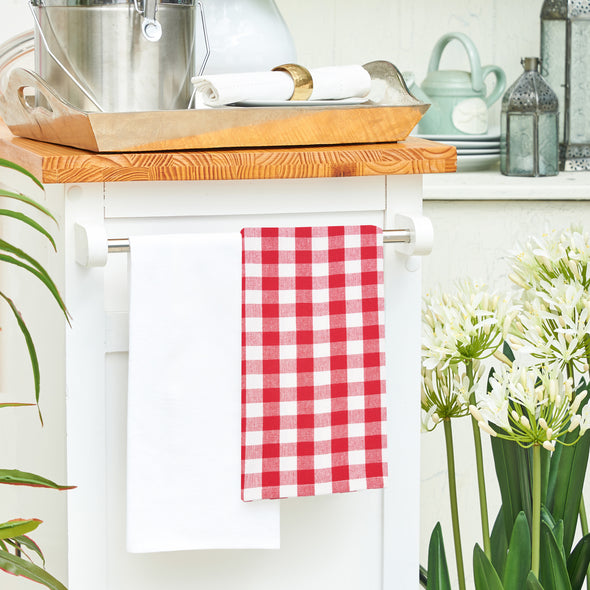 woven red and white checkered gingham kitchen towel hanging from a kitchen countertop