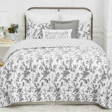 intricate black floral quilt with a crosstitch pattern on the reverse side