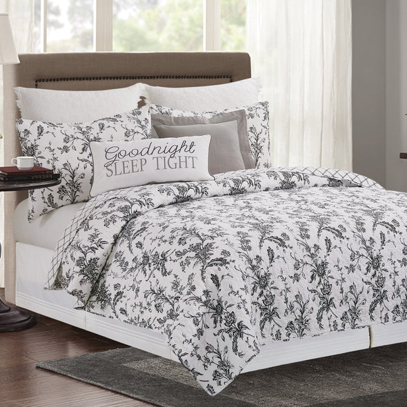 intricate black floral quilt with a crosstitch pattern on the reverse side