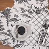 quilted table linen collection with an intricate black floral pattern that reverses to a simple plaid