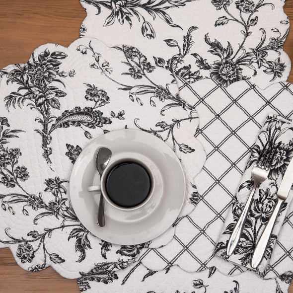 quilted table linen collection with an intricate black floral pattern that reverses to a simple plaid