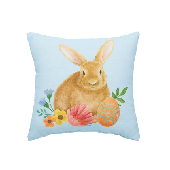 This pillow features a printed design of a brown bunny surrounded by sprigs of flowers & Easter eggs on a blue ground.