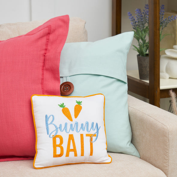 bunny bait pillow on a couch with a pink and blue pillow