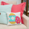 easter egg mini hooked pillow on a couch with a blue and pink pillow