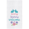 flour sack towel with the phrase every bunny welcome in bright spring colors. two bunnies sit on top of the phrase while a group of flowers are below