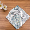 quilted table linens featuring blue and grey medallion pattern with pops of yellow that reverse to a coordinating repeating medallion pattern in grey and yellow