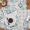 quilted table linens featuring blue and grey medallion pattern with pops of yellow that reverse to a coordinating repeating medallion pattern in grey and yellow