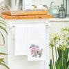 flour sack towel with an array of hibiscus flowers and a graceful hummingbird drinking from the blooms hanging from a counter