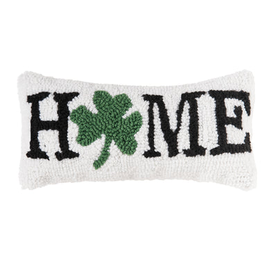 white hooked pillow with "Home" written in black with a green shamrock in place of the O