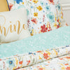 quilt with a watercolor inspired wildflower print in vibrant red, yellow, and blue flowers that reverses to a coordinating blue with an abstract foliage style print