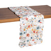 quilted table linens with a watercolor inspired pattern of wildflowers in bright colors including red, orange, and blue that reverses to a coordinating blue and a simple abstract foliage style pattern