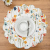 quilted table linens with a watercolor inspired pattern of wildflowers in bright colors including red, orange, and blue that reverses to a coordinating blue and a simple abstract foliage style pattern