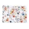 quilted table linens with a watercolor inspired pattern of wildflowers in bright colors including red, orange, and blue that reverses to a coordinating blue and a simple abstract foliage style pattern