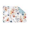 quilted table linens with a watercolor inspired pattern of wildflowers in bright colors including red, orange, and blue that reverses to a coordinating blue and a simple abstract foliage style pattern