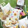 spring home decor pillows and kitchen towels with floral motifs in a garden setting