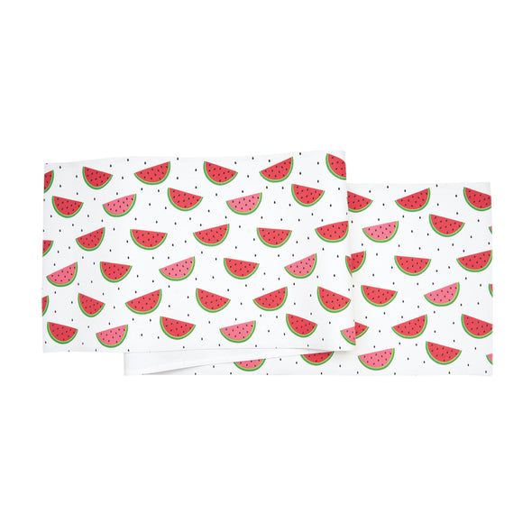printed table linens with watermelon slices surrounded by little black seeds paired with a red and white striped napkin