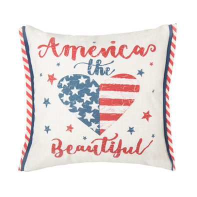 a printed pillow with the phrase America the Beautiful in a distressed flourishing script. the center of the pillow features a heart resembling an American flag and two sides are trimmed in white and red stripes