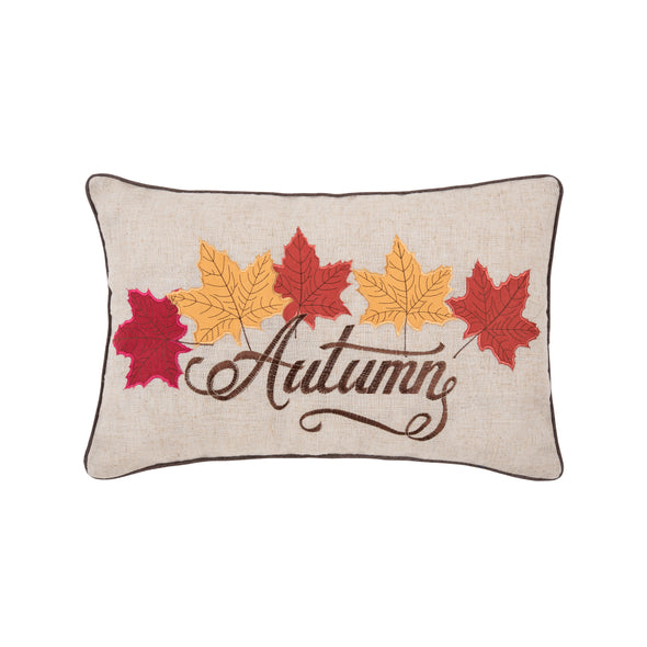 embroidered pillow with the work Autumn in a flourishing text that has orange and yellow maple leaves on the top. the pillow has a rustic natural background