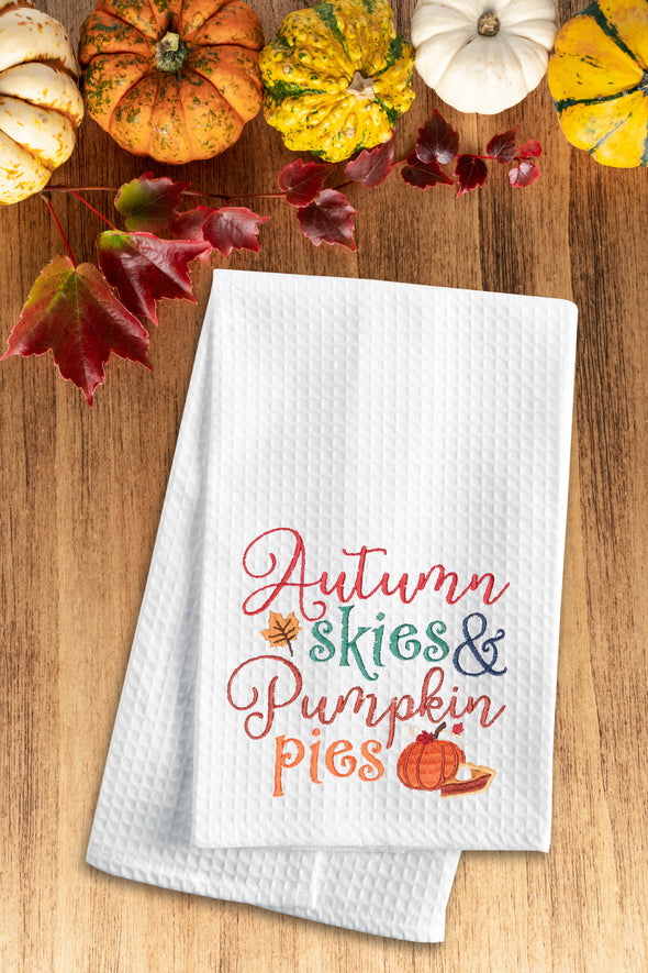 Embroidered Autumn Skies & Pumpkin Pies kitchen towel styled on a fall flat lay.