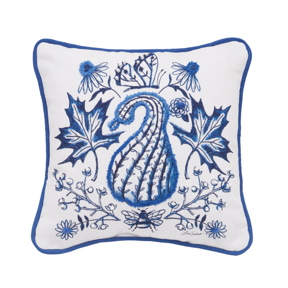 White pillow with a gourd, leaves, flowers, and butterfly and bee accents with a blue piped border