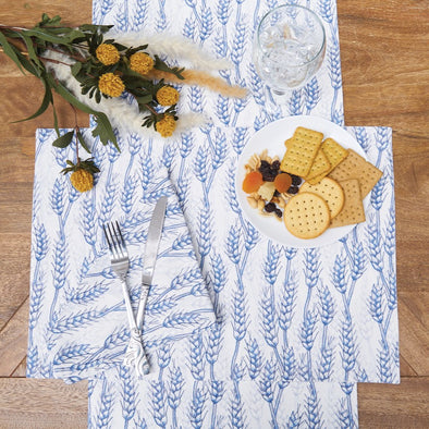 table set with the blue hervest wheat table linens with flowers and a snack