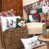 woodland creatures dressed in winter gear and embroidered holiday pillows in a basket