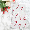 printed kitchen towel with red and white candy canes all over on a marble countertop