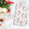 printed kitchen towel with red and white candy canes all over on a marble countertop