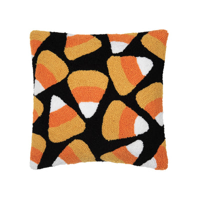 black hooked pillow with orange yellow and white candy corn pieces scattered in an all over pattern