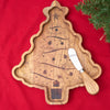 christmas shaped serving board made from acacia wood with a spreader on a table with a red runner