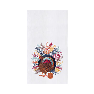 flour sack towel with detailed feathers spanning across the back of a turkey in a variety of fall colors standing next to a pumpkin