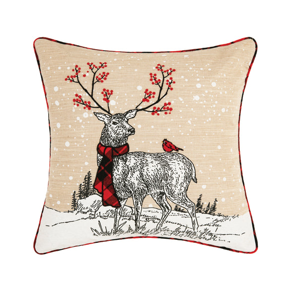 deer pillow that is tan with a deer wearing a red and black plaid scarf  with a red cardinal on its back on a snowy landscape