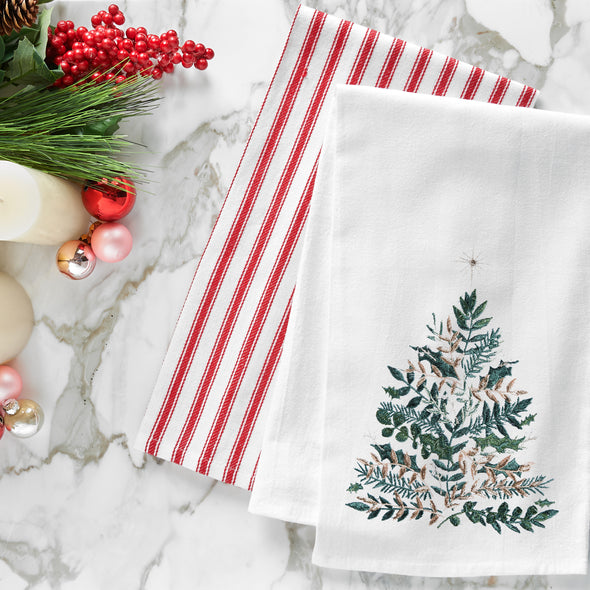 embroidered flour sack towel with artwork by Lori Siebert of an emerald Christmas tree with gold accents and a simmering star on top on a marble countertop