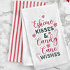 embroidered flour sack towel with the phrase eskimo kisss and candy cane wishes surrounded by snowflakes and candy canes on a marble countertop