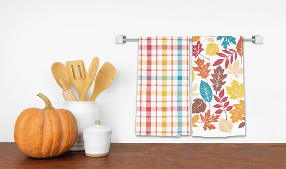 Fall Leaves & Plaid Kitchen Towel Set hung from a kitchen towel bar.