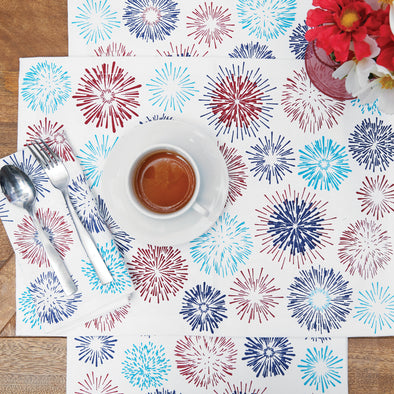 printed table linens with red and blue firework bursts on a wood table with flowers