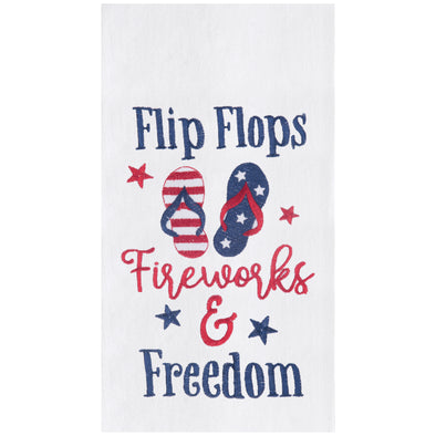 flour sack towel with the words flip flops fireworks & freedom paired with a pair of flip flops that have a patriotic design of red and white stripes while the other has a blue background with white stars