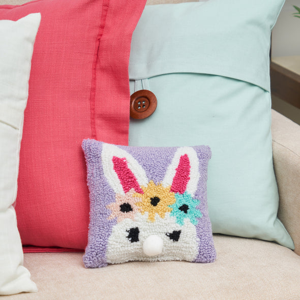 floral bunny hooked mini pillow on a couch with a pink and blue pillow