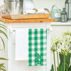 woven applique kitchen towel with a green and white plaid background and the word LUCK in clovers hanging from a kitchen counter