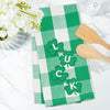 woven applique kitchen towel with a green and white plaid background and the word LUCK in clovers on a marble counter