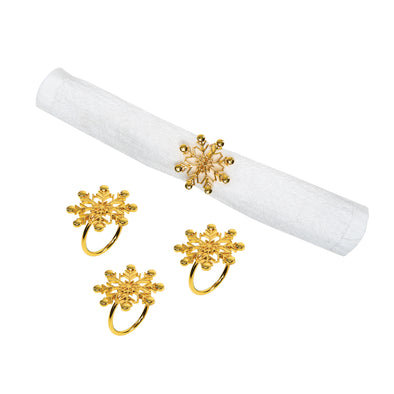 gold napkin rings shaped like snowflakes - one wrapped around a white napkin