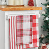 red and white plaid woven kitchen towel on a marble hanging from a kitchen countertop next to other holiday kitchen towels