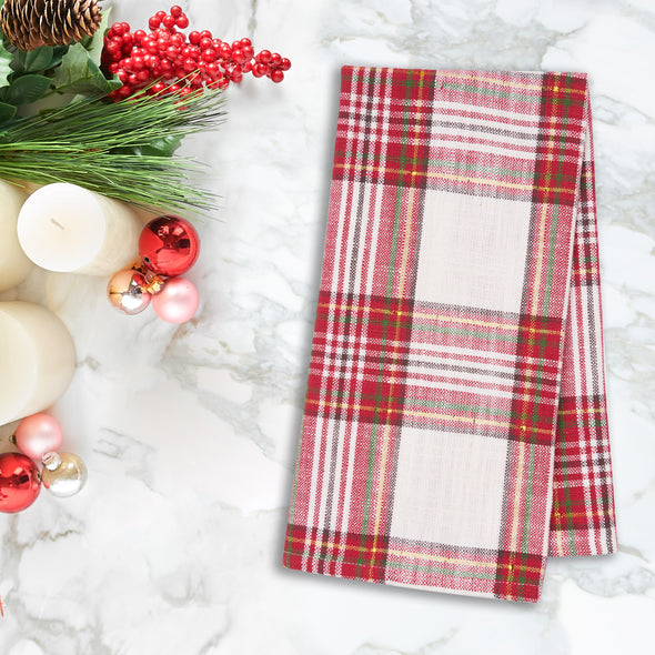 red and white plaid woven kitchen towel on a marble countertop next to holiday decor