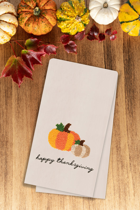 happy thanksgiving french knot kitchen towel styled on a fall themed flatlay