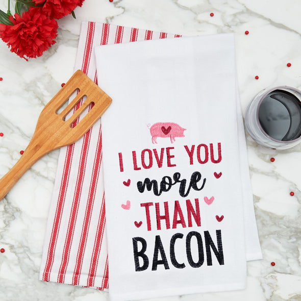 flour sack towel with the phrase I love you more than bacon surrounded by pink and red hearts on a marble counter