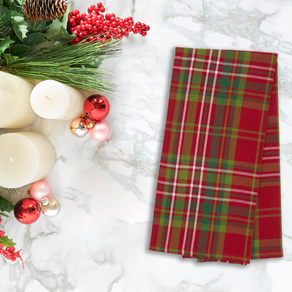 red and green woven plaid kitchen towel on a marble counter next to holiday decor