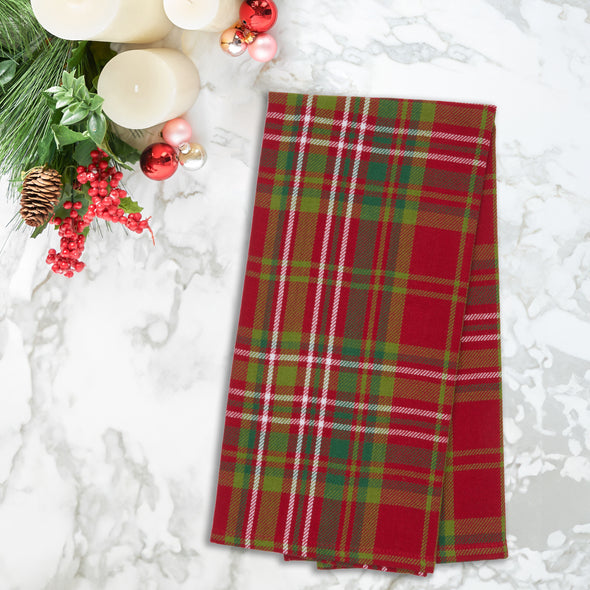 red and green woven plaid kitchen towel on a marble counter next to holiday decor