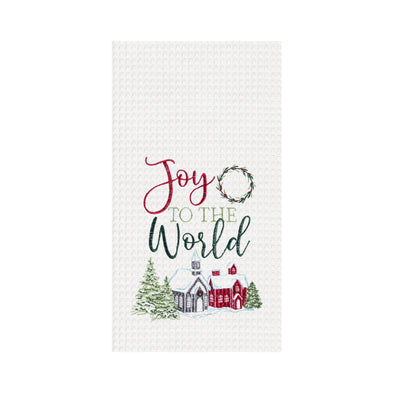 waffle weave towel with the phrase Joy to the World nestled between a wreath and above a snow covered town decorated for the holidays