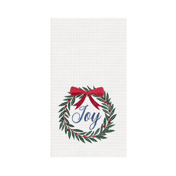 waffle weave towel with a wreath topped with a red bow and the word joy in the center