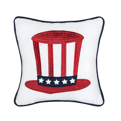 an embroidered pillow with the iconic Uncle Sam hat in red on a crisp white background. the pillow is trimmed in a complementary blue